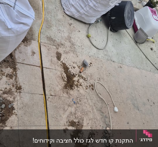 תיק כלים, שקי חצץ, כבל צהוב, חפירה ברצפה